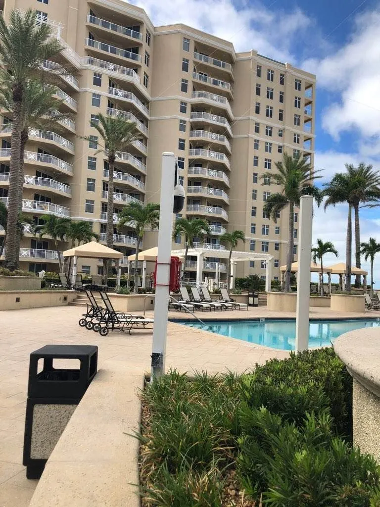 Weatherproof CCTV camera overlooking a luxury hi-rise swimming pool on the beach.